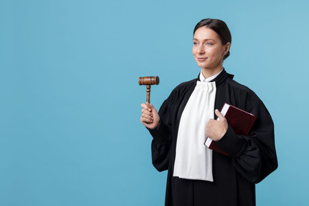 Judge with mallet and book on light blue background, space for textの写真素材