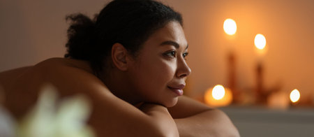 Beautiful woman relaxing on massage couch in spa salon, space for text