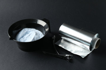 Bleaching powder and hairdresser's tools on black background, closeupの写真素材