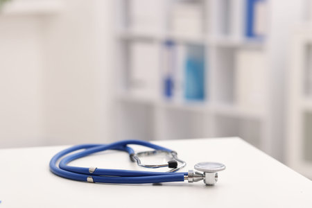 Doctor's workplace. Stethoscope on white table in medical office, closeup. Space for textの写真素材