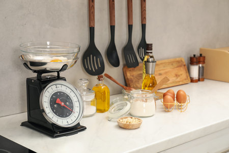 Retro mechanical kitchen scale and different food products on white marble countertop indoorsの写真素材