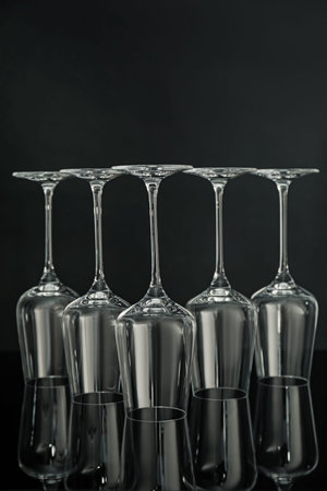 Many empty clean glasses on mirror surface against black backgroundの写真素材
