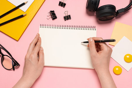 Woman with planner and stationery on pink background, top viewの写真素材