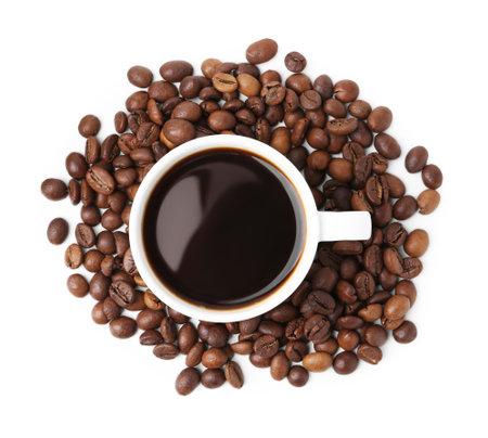 Aromatic coffee in cup and pile of beans isolated on white, top viewの写真素材