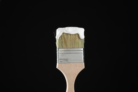 Brush with white paint on black background, closeupの写真素材
