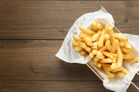 Tasty french fries on wooden table, top view. Space for textの写真素材
