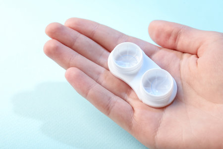 Woman with contact lenses on light blue background, closeupの写真素材