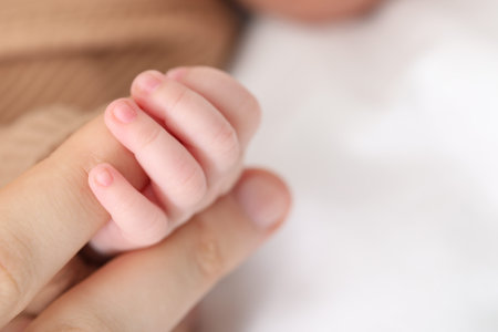 Mother with her little baby on bed indoors, closeup. Space for text