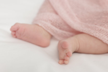 Cute little baby lying on bed at home, closeupの写真素材