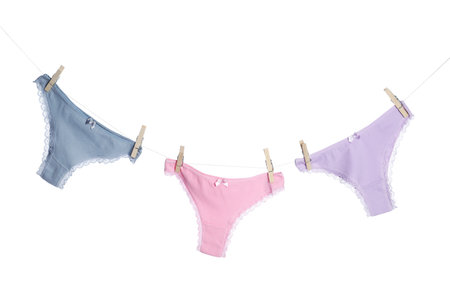 Women's underwear. Beautiful panties on clothes line against white backgroundの写真素材