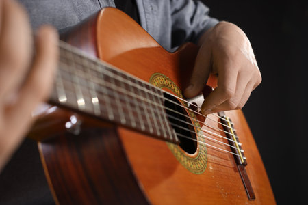 Man playing guitar on black background, closeupの写真素材