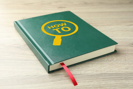 How To book on wooden table, closeup. User guide