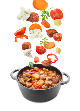 Delicious cooked stew. Fresh ingredients falling into pot on white backgroundの写真素材