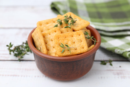 Tasty salty crackers with thyme on white wooden table, closeupの写真素材
