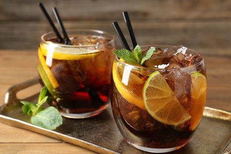 Refreshing Cuba libre cocktail with mint on wooden table, closeupの写真素材