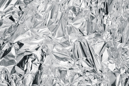 Crumpled aluminum foil as background, top view