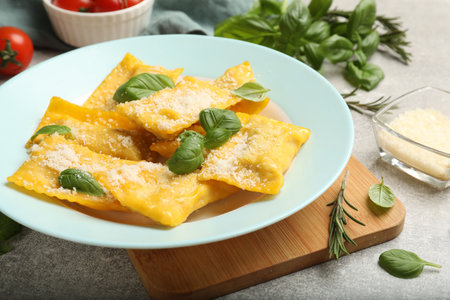 Delicious ravioli with cheese and basil served on grey table, closeupの写真素材