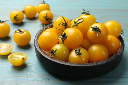 Many fresh yellow tomatoes on blue wooden table, closeupの写真素材