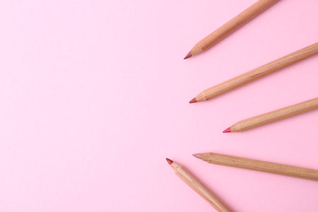 Many different pencils on light pink background, flat lay. Space for textの写真素材