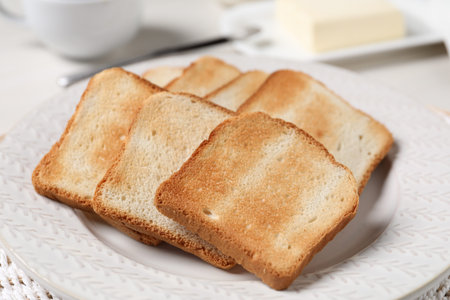 Slices of tasty toasted bread on white table, closeup