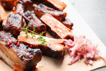 Delicious pork ribs, thyme and onion on grey table, closeupの写真素材