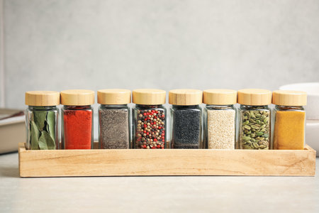 Different aromatic spices in jars on light tableの写真素材
