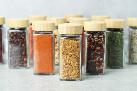 Many different aromatic spices in jars on table indoors, closeup