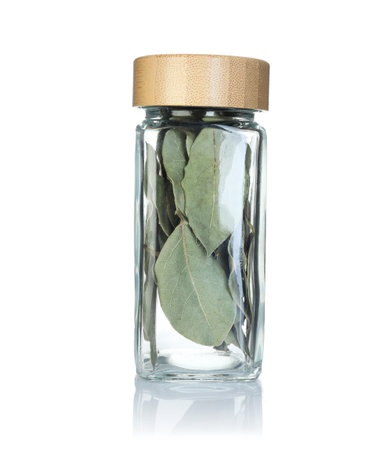 Bay leaves in spice jar isolated on whiteの写真素材