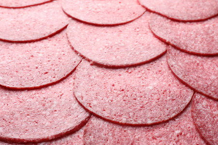 Slices of tasty smoked sausage as background, closeup