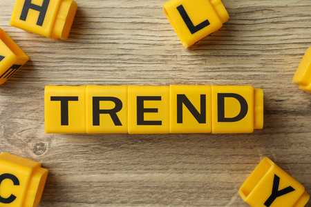 Word Trend made of yellow cubes with letters on wooden background, top viewの写真素材