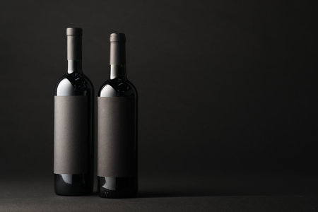 Bottles of wine on black background, space for textの写真素材