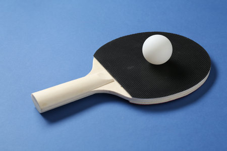 Ping pong racket and ball on blue background, closeupの写真素材