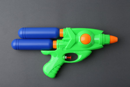 Bright plastic water gun on grey background, top viewの写真素材