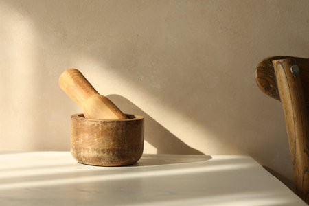 Wooden mortar and pestle on white table indoorsの写真素材
