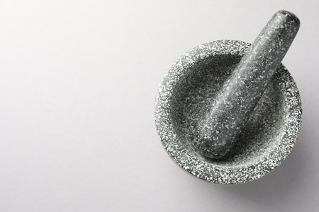 Stone mortar and pestle on light grey background, top view. Space for textの写真素材