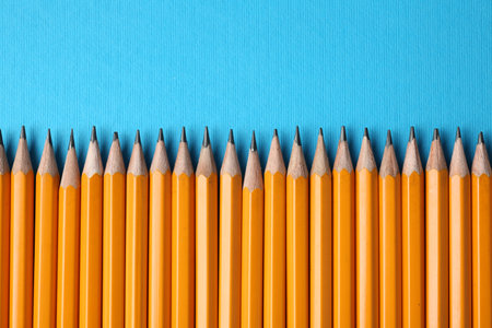 Graphite pencils on light blue background, flat lay. Space for textの写真素材
