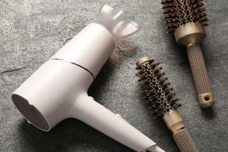 Different hairstyling tools on grey textured background, closeupの写真素材