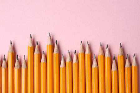 Sharp graphite pencils on pink background, flat lay. Space for text
