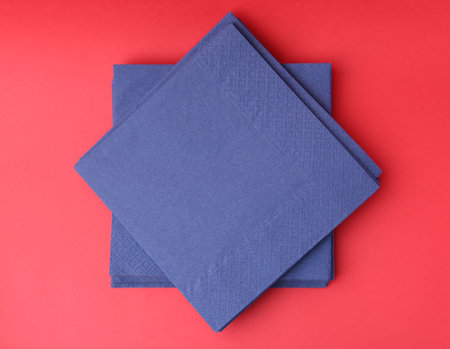 Stack of blue handkerchiefs on red background, top viewの写真素材