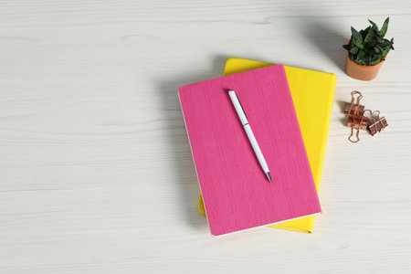 Flat lay composition with office supplies and houseplant on light wooden table. Space for textの写真素材