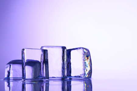 Cubes of clear ice on violet background, closeup. Space for textの写真素材