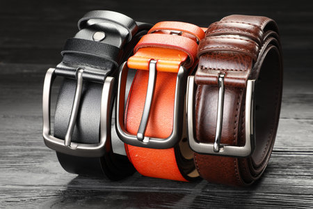 Three leather belts on wooden table, closeupの写真素材