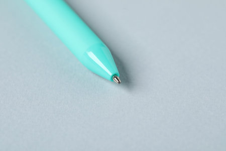 One ballpoint pen on grey background, macro view. Space for text