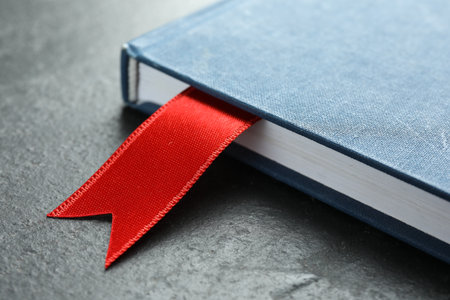 Planner with red ribbon bookmark on grey textured table, closeupの写真素材