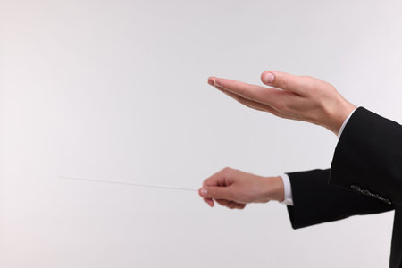 Conductor with baton on light grey background, closeup. Space for textの写真素材