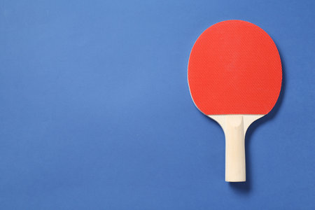 One ping pong racket on blue background, top view. Space for textの写真素材