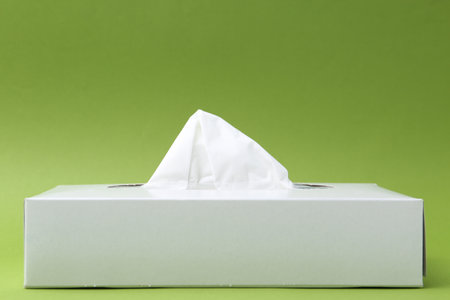 Box with paper handkerchiefs on green background. Space for textの写真素材