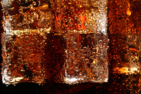 Refreshing cola with ice as background, macro viewの写真素材