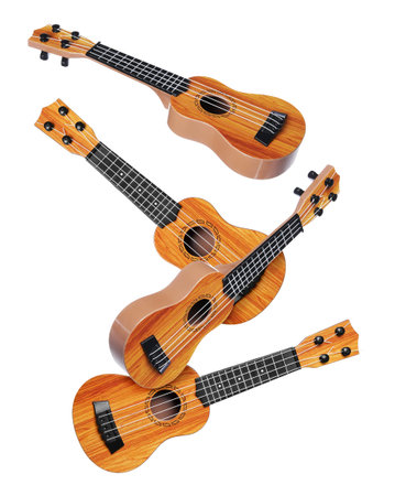 Toy guitars in air on white background. Child's musical instrument