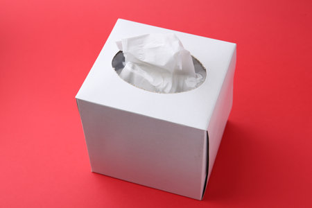 Box with paper handkerchiefs on red background, closeupの写真素材